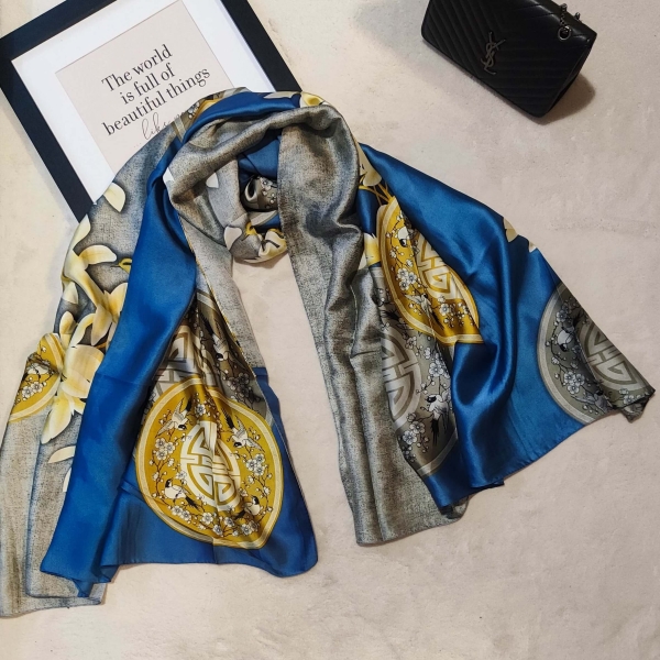 Luxurious satin scarf in blue and gold with floral motifs, made of viscose and silk