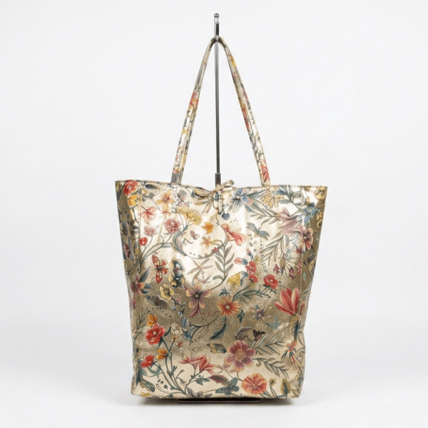 Elegant golden handbag with flowers made of genuine leather, shown full-length with long and sturdy handles for comfortable shoulder carrying.