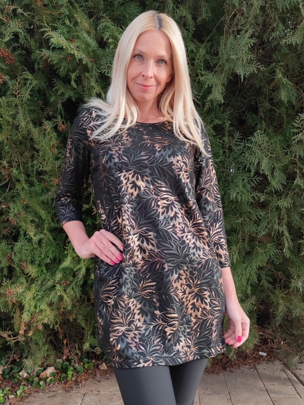 Жена облечена в черна туника със златни нюанси и зелен фон