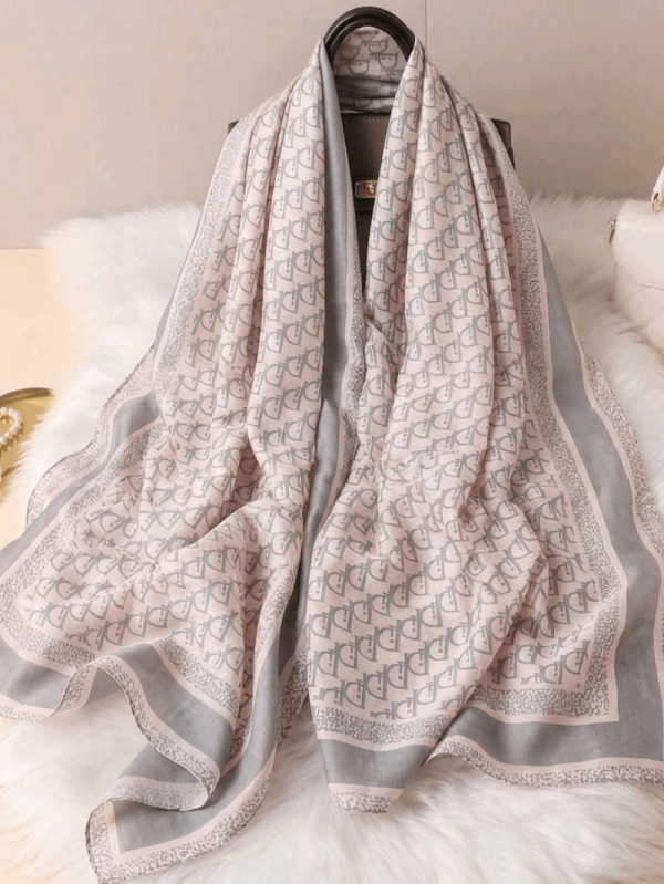 Unfolded satin silk scarf with a gray monogram, pink outline and gray textured border showing the entire print and size 190x90.