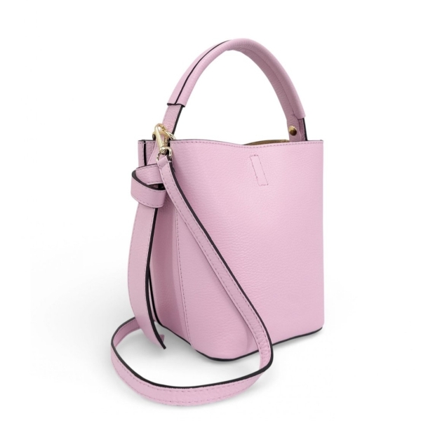 Страничен профил на розова структурирана кожена дамска чанта. Показва къса дръжка, прикрепване за дълга презрамка и стабилно твърдо дъно с метални крачета