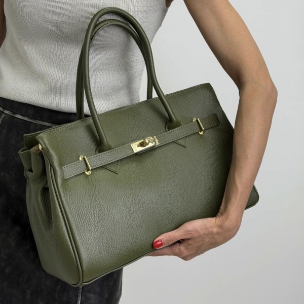 A model holding an elegant olive-green handbag with gold details.