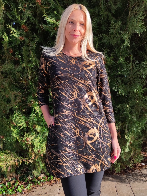 Жена облечена в черна туника със златни нюанси и зелен фон