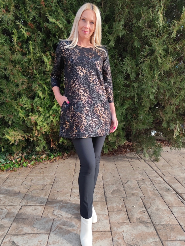 Жена облечена в черна туника със златни нюанси и зелен фон