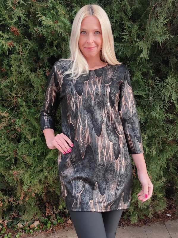 Woman wearing a black tunic with gold accents