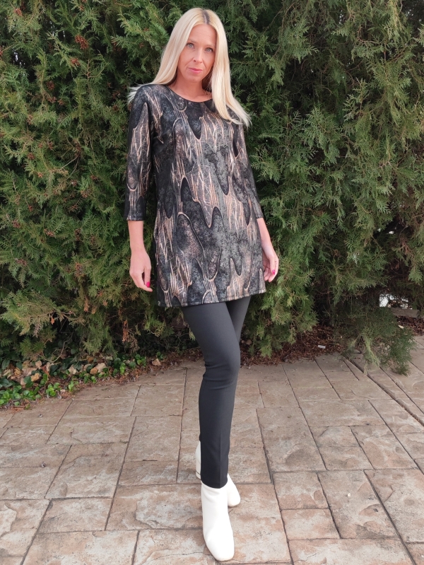 Woman wearing a black tunic with gold accents