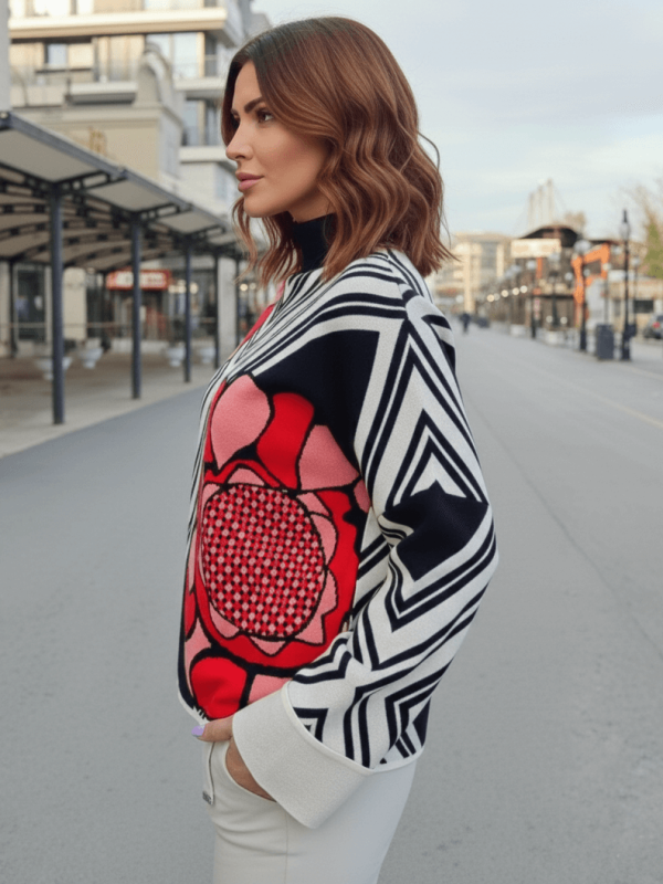 Side view of a women's sweater with a red flower and black and white patterns.
