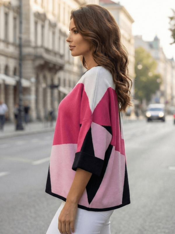 Жена, носеща свободен вискозен пуловер с модерни геометрични фигури в розово, бяло и черно