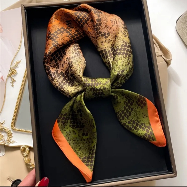 Сатенена кърпа за врата в оранжево и зелено, вързана на панделка.