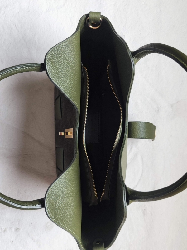 Interior layout of a women's handbag with a zipper and a compartment, top view.