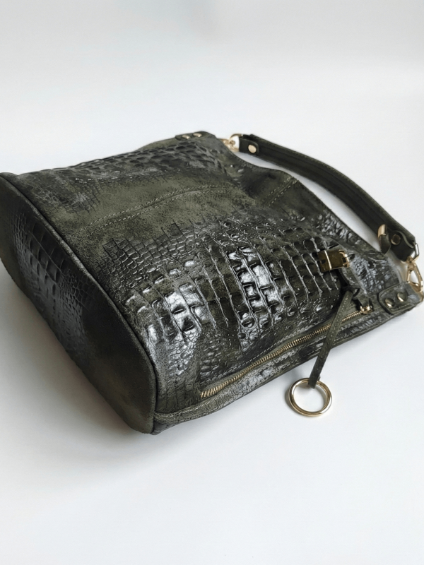 Елегантна жена с кожено палто и зелена чанта от велур