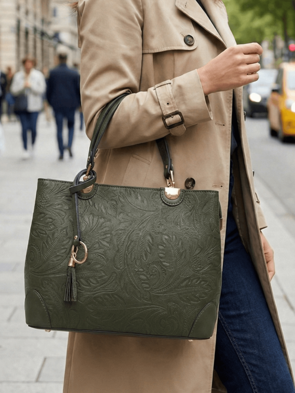 Дамска чанта в маслинено зелено, носена от модел в градска среда, съчетана с елегантен тренчкот
