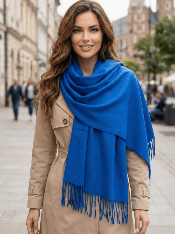 "A woman with brown hair wears an elegant blue cashmere scarf