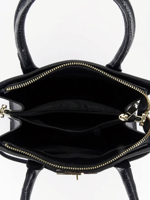 Interior of the bag with three compartments, a middle pocket with a zipper and a black lining.