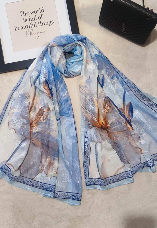 Елегантен дамски шал от вискоза и коприна в светло синьо, сгънат до дамска чанта.