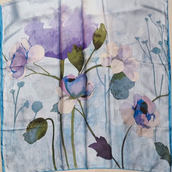 Сгънат луксозен шал в светло синьо с лилави цветя, материя сатен.