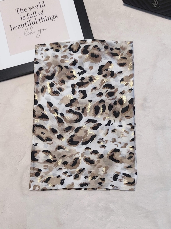 Детайл на дамски шал от вискоза с животински принт и блестящи златни акценти.