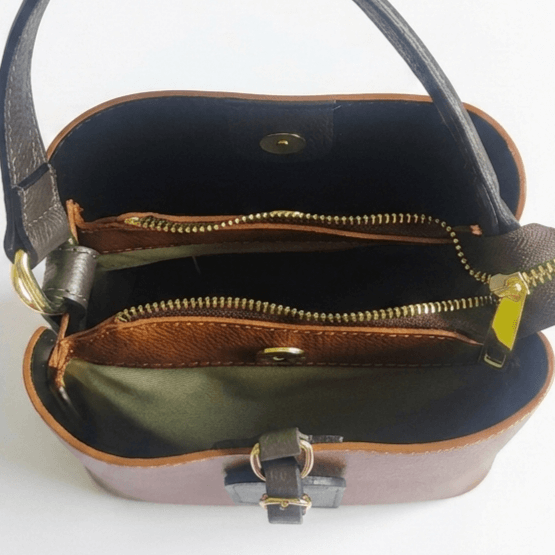 Interior layout of a leather handbag with two compartments, a middle pocket with a zipper and magnetic closure.