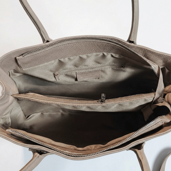 Изглед отвътре на бежова дамска чанта, показващ три удобни отделения, среден джоб с цип, бежов хастар и кожен етикет Vera Pelle.