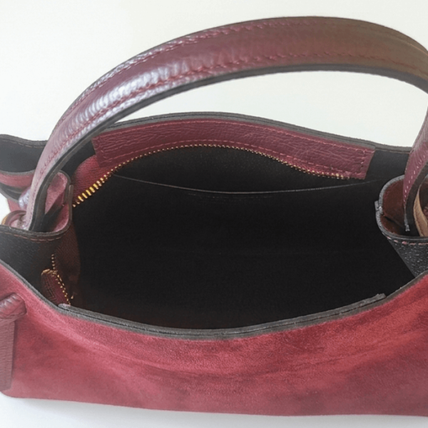 Elegant burgundy bag made of natural suede with a trapezoidal shape, decorative leather knots and a fine handle