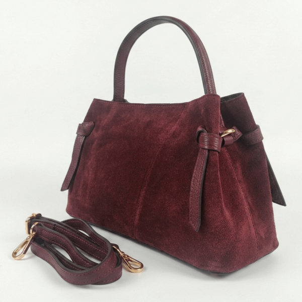 Elegant burgundy bag made of natural suede with a trapezoidal shape, decorative leather knots and a fine handle