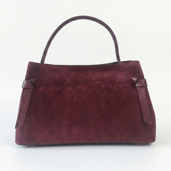 Elegant burgundy bag made of natural suede with a trapezoidal shape, decorative leather knots and a fine handle