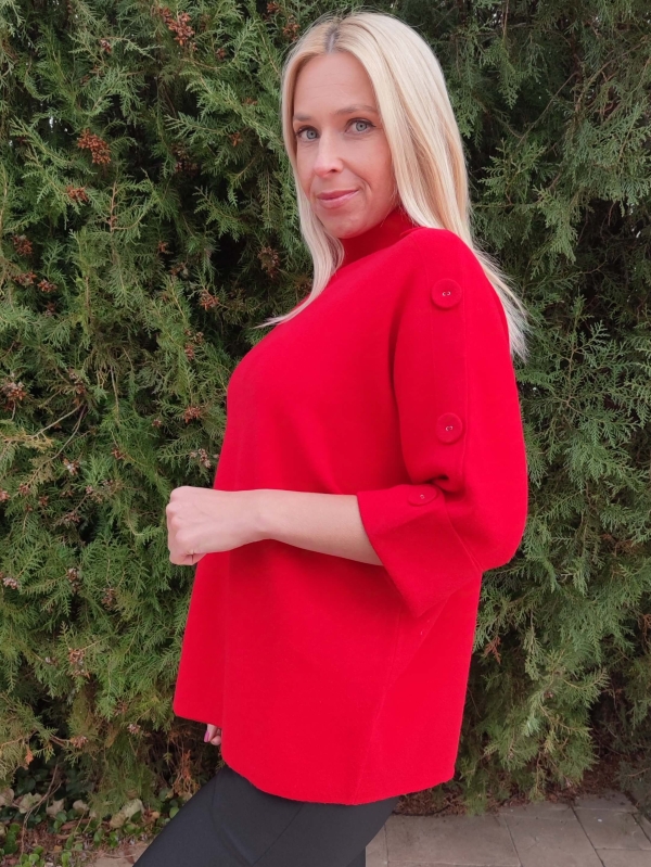 Detail of decorative buttons on the short sleeve and shoulder of a red women's sweater