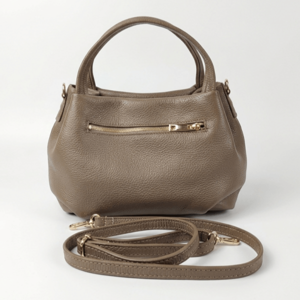 Back of a dark beige leather handbag with a convenient outer zip pocket and a long adjustable shoulder strap.