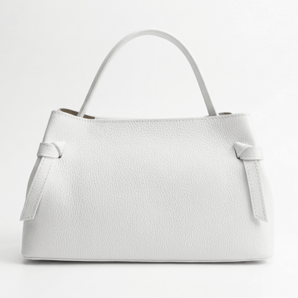 Frontal photo of an elegant white handbag made of embossed genuine leather with decorative knots and a hard handle on a white background