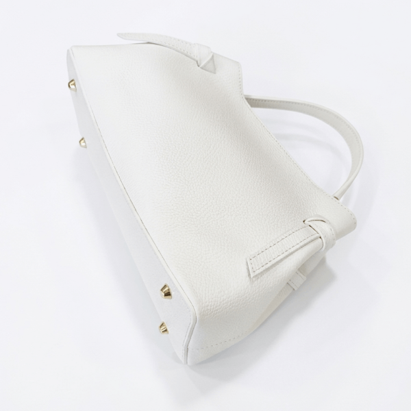 Bottom and side view of a white leather handbag, showing the protective metal feet in gold.