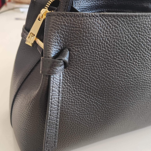 Черна дамска чанта с къса дръжка, златисти детайли и декоративни кожени възли.