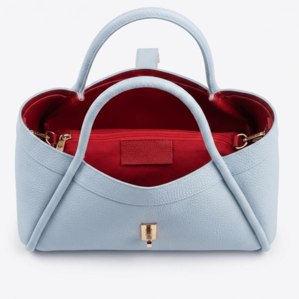 Вътрешност на дамска чанта от естествена кожа с червена подплата и несесер