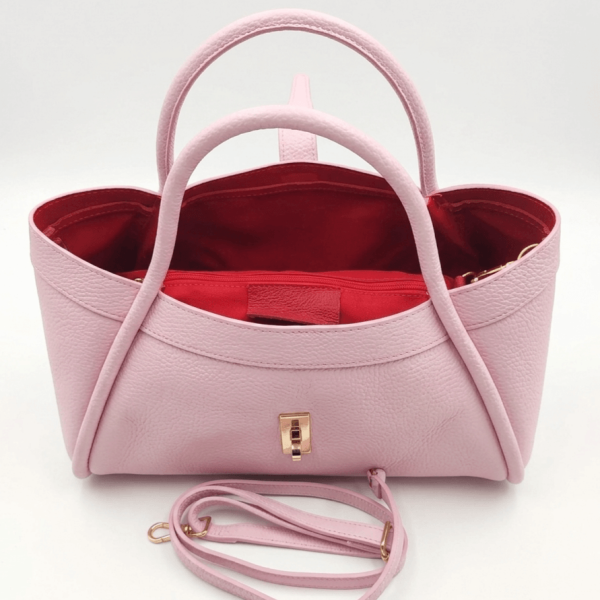 Interior of a pink bag with red lining and a toiletry bag
