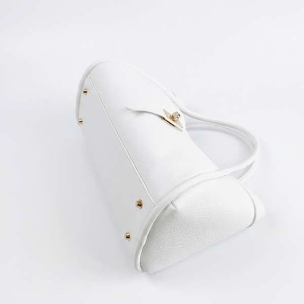 Дъно на бяла ръчно изработена чанта с предпазни метални крачета