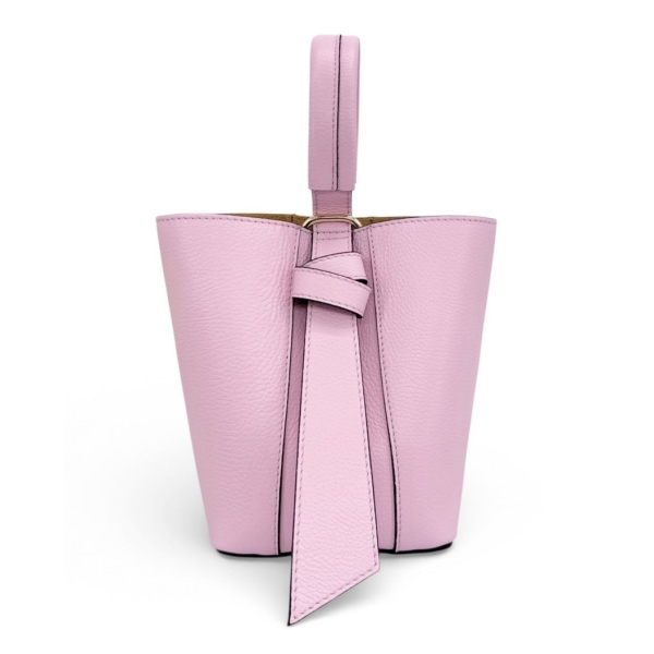 Розова елегантна дамска чанта Vera Pelle. Преден изглед на стояща структурирана чанта, показващ късата дръжка и декоративен възел. Твърдо дъно за стабилност."