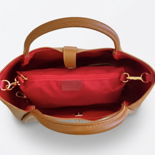 Inside view of a brown leather bag with red lining and organizer