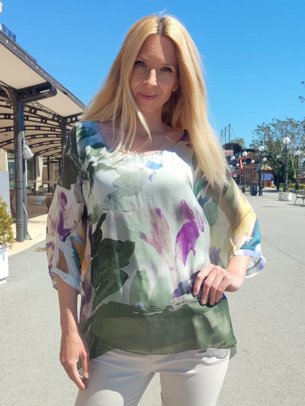 Women's airy silk blouse with an asymmetrical hem and an abstract watercolor print in green