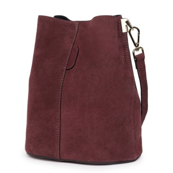 Side view of a luxury burgundy genuine suede women's handbag with a rigid bottom.