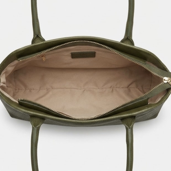 Interior layout of a spacious olive-green leather bag with light-colored lining and a zippered pocket.