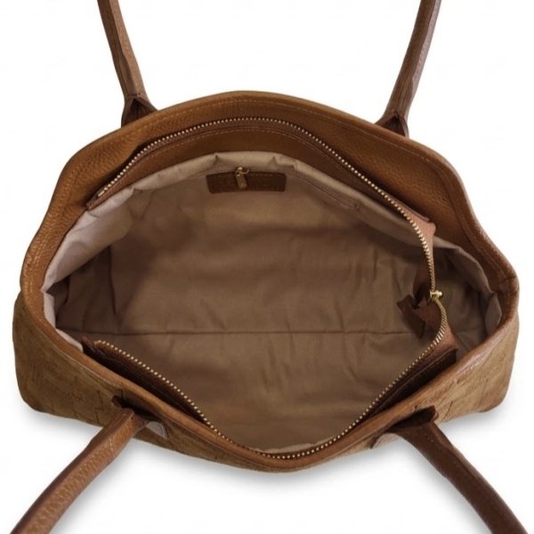 Interior layout of a spacious light-brown leather bag with a light-colored lining and a zippered pocket.