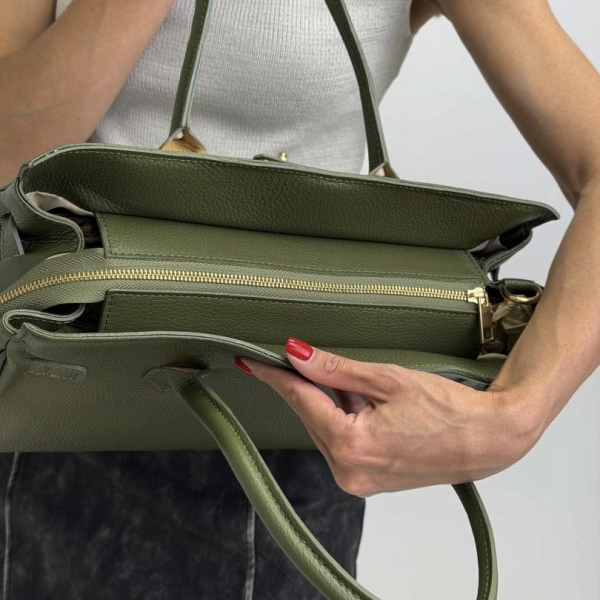 Close-up view of the zipper on an olive-green Italian bag.