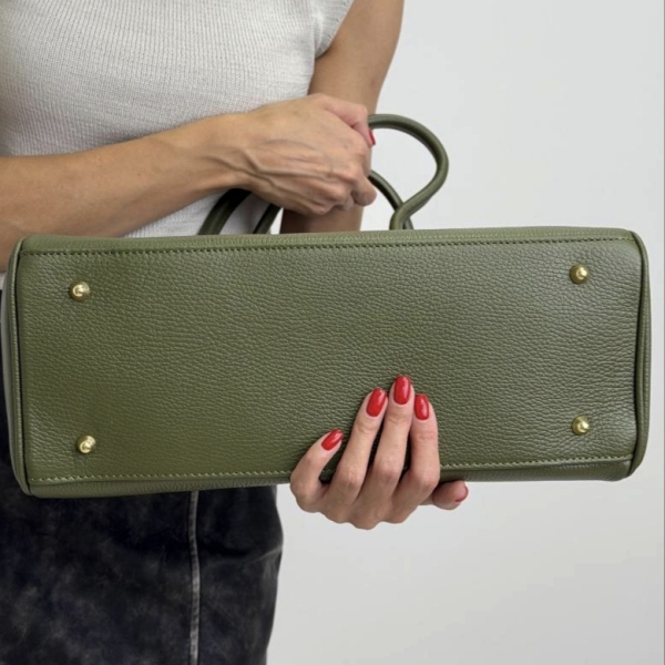 Bottom of an olive-green women's handbag with gold metal feet.