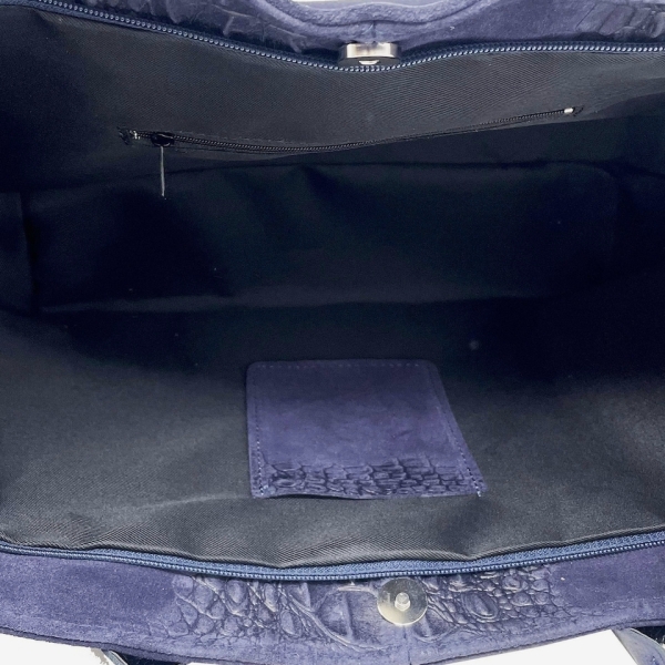 Interior layout of a leather bag, featuring a zippered pocket and a phone compartment.