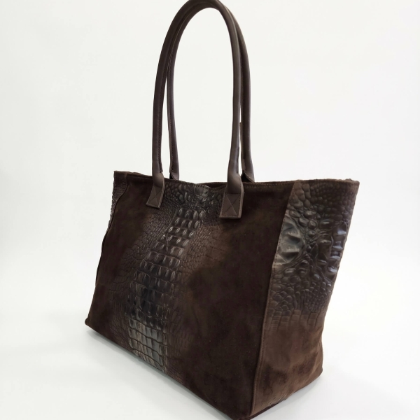 Profile view of a large, chocolate-colored women's handbag with leather shoulder straps