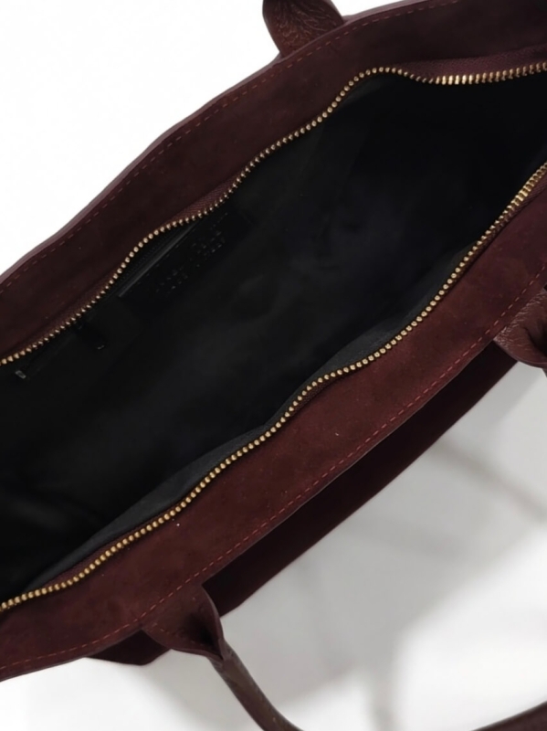 Internal zippered compartment in a burgundy suede women's bag