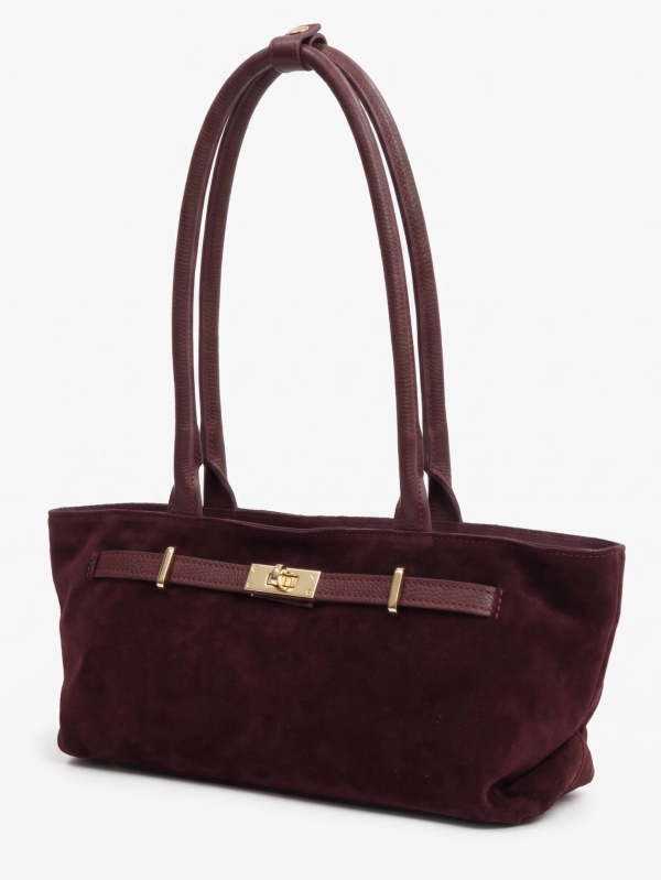 Decorative gold-tone fastening on a stylish burgundy suede bag