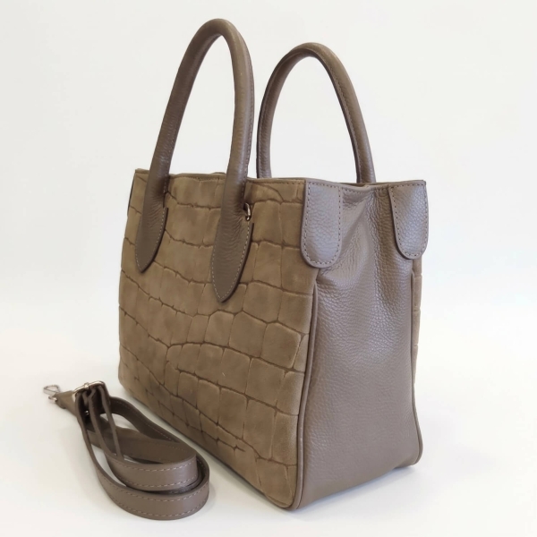 Side view of an Italian women's handbag made of taupe leather and suede, featuring short handles and a long shoulder strap.
