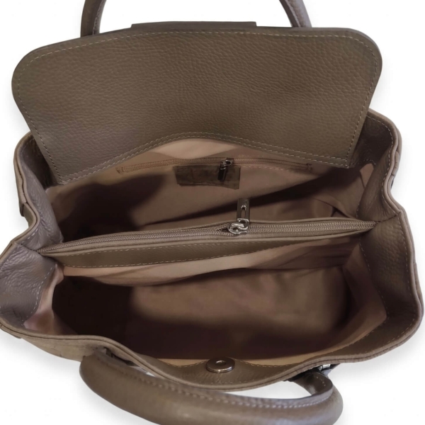 Interior layout of a women's handbag featuring three compartments, a central zippered section, and a light-colored lining.